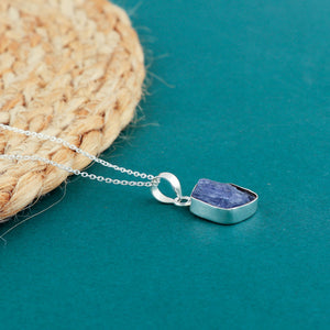 Real tanzanite raw crystal pendant necklaces arranged in a row with blue rough stones in bezel settings on silver-plated chains