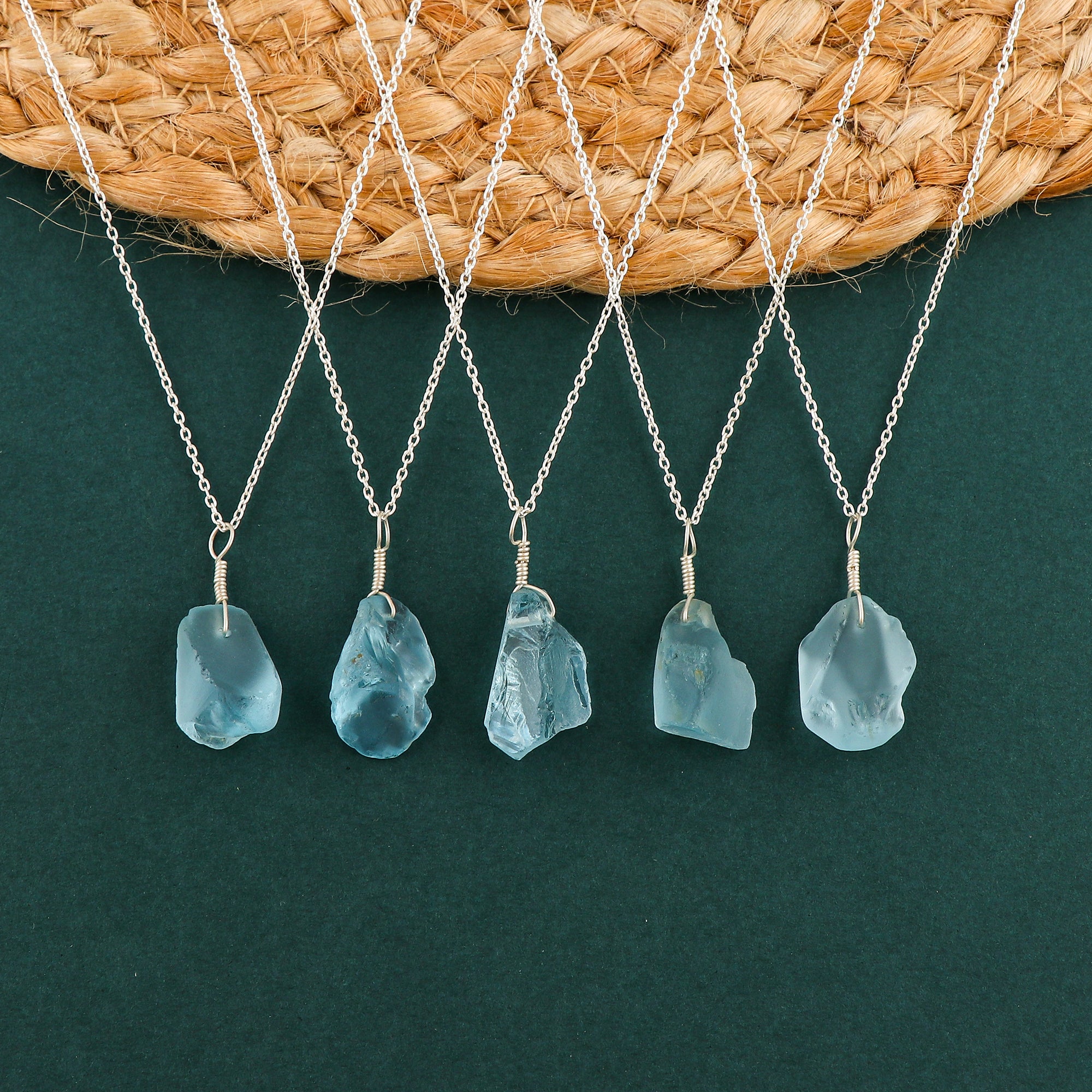Sky blue topaz raw crystal pendant necklaces arranged in a row showing irregular gemstone shapes on silver-plated chains