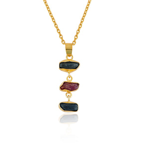 Raw sapphire and ruby crystal pendant necklace in gold-plated bezel displayed on white background showing vibrant blue and pink stones