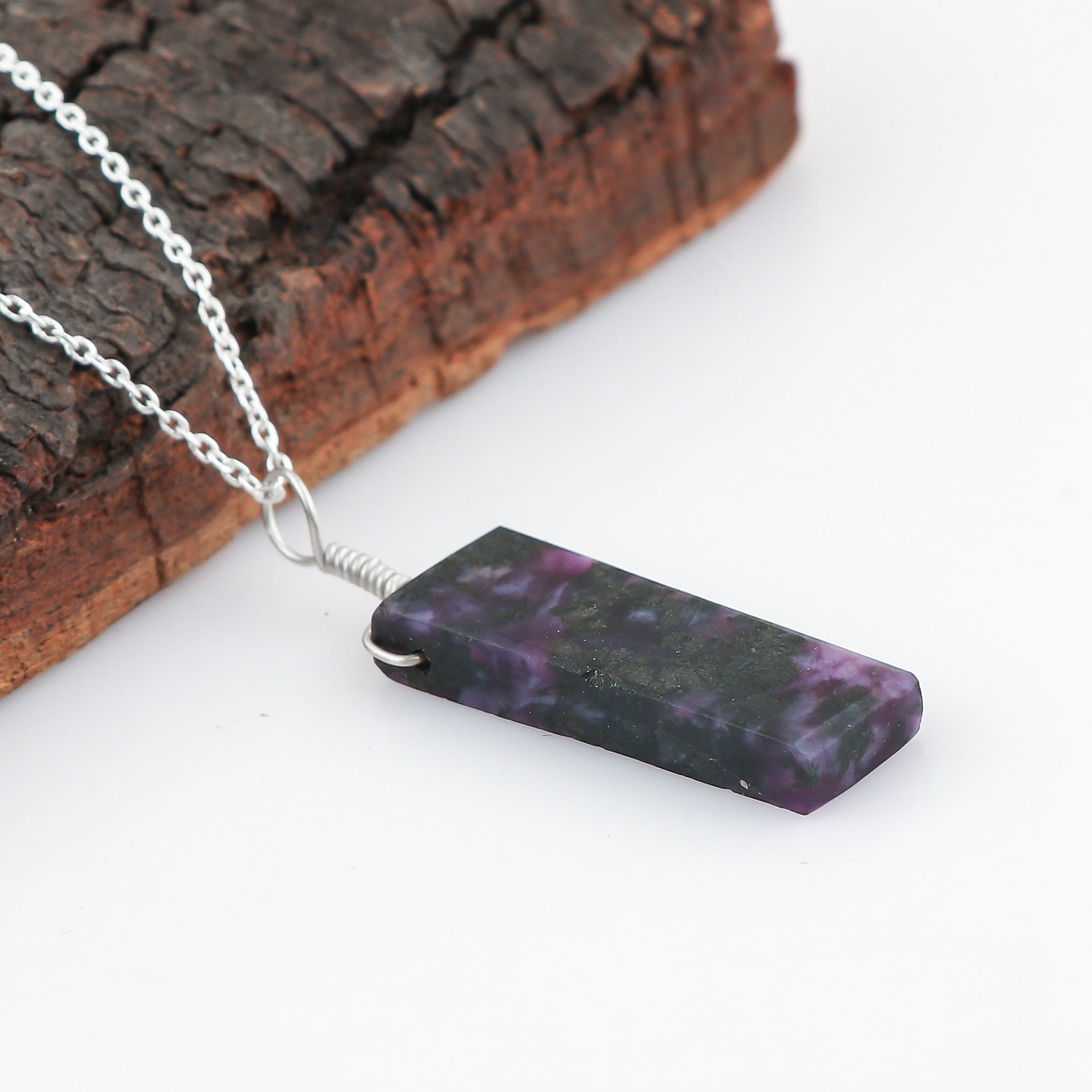 Necklace with a purple and black marbled pendant on a white background
