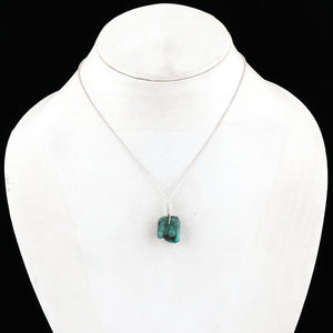 Green pendant necklace on a mannequin with a black background