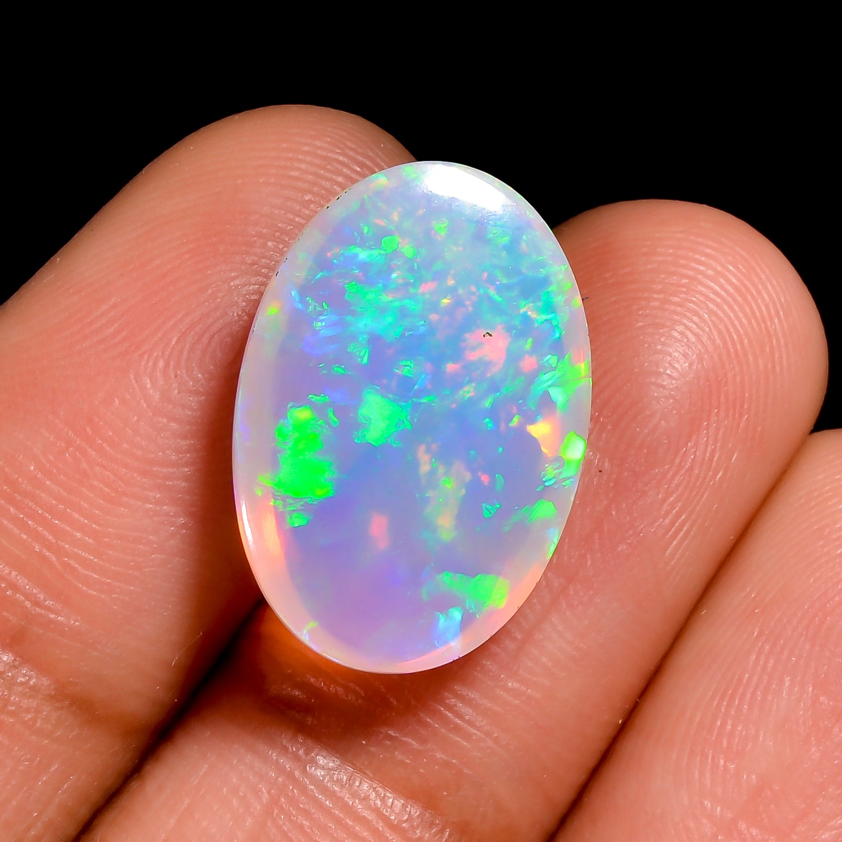 Oval-shaped 5.50 carat white Ethiopian opal cabochon with vivid play-of-fire. 

